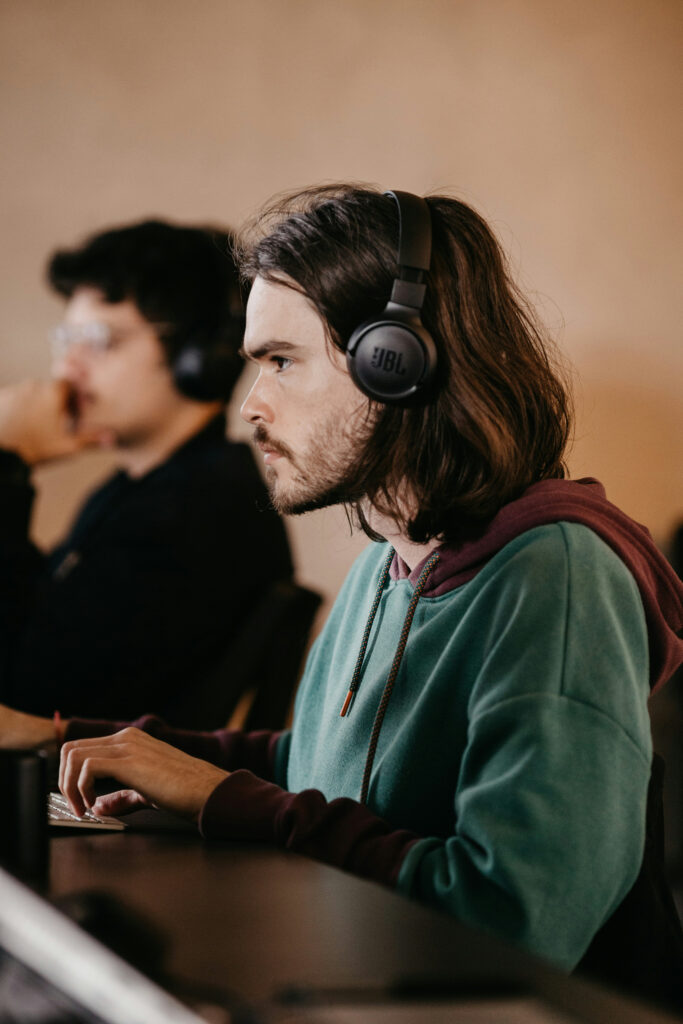 Man with headphones working intently at computer